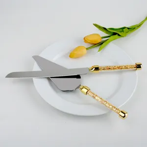 Detalle de mangos de cristal dorado en el elegante juego de cuchillo y pala para tarta.