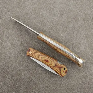 Detail of a sharp folding knife featuring a colorful wood handle and stainless steel blade.