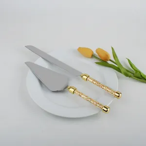 Detalle de set de cuchillo y pala para tarta de acero con mangos de cristal dorado