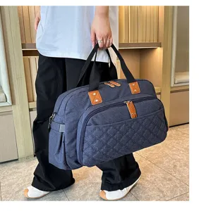 Vue détaillée du grand sac de voyage avec texture matelassée et poignées robustes.