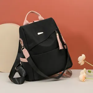 Large capacity women's anti-theft backpack in black and pink with decorative tassel