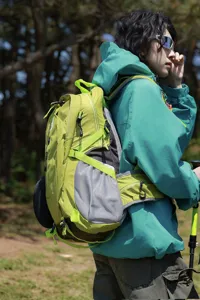 Gedetailleerd zijaanzicht van een limoengroene wandelrugzak voor outdoor trekking en reizen