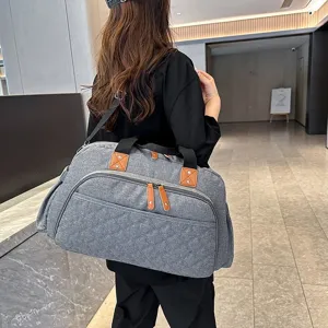 Grand sac de voyage gris avec sangle pour valise et séparation sec humide pour le sport.