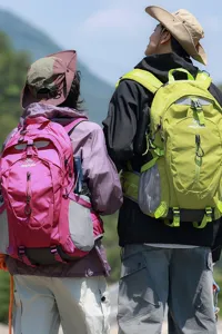 Achteraanzicht van wandelaars met magenta en limoengroene outdoor rugzakken