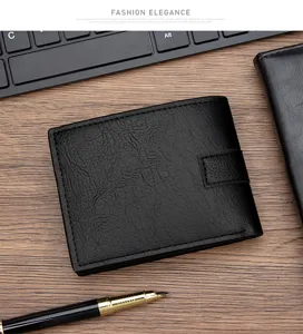 Close-up of a men's vintage black leather short wallet displayed on a professional wooden desk.