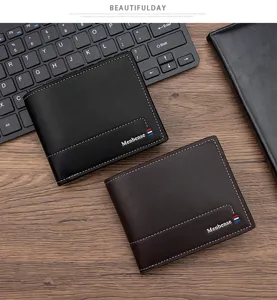 Vista detallada de carteras Menbense negras y marrones en escritorio con teclado y bloc