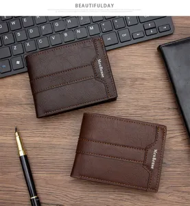 Detailed view of two vintage brown leather men's wallets on a desk with keyboard and pen