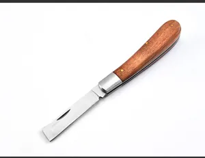 Primer plano de una navaja plegable que muestra la hoja de acero y el mango de madera