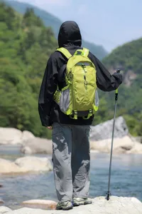 Groene outdoor wandelrugzak in een bergachtige omgeving met een trekkingstok