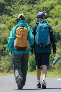 Twee wandelaars met grote trekkingrugzakken op een schilderachtige bergweg in de buitenlucht