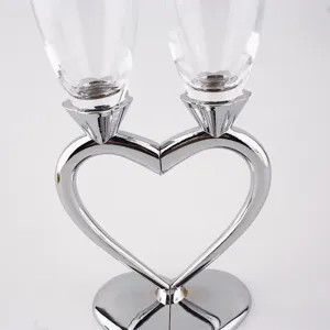 Close-up of elegant crystal champagne flutes with heart-shaped silver metallic base.