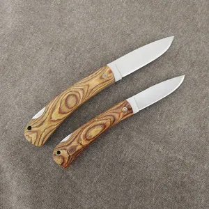 Detailed macro view of two folding utility knives with colorful wood handles on burlap