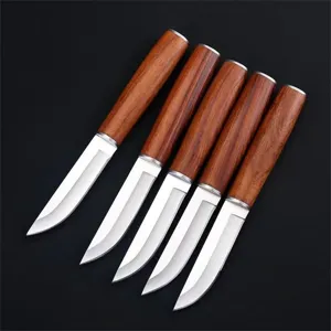 Close-up of five Mongolian style meat knives with rosewood handles on a black surface