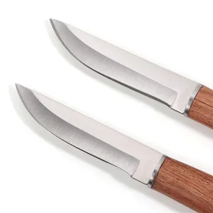 Close-up detail of sharp stainless steel meat knives featuring natural sandalwood handles