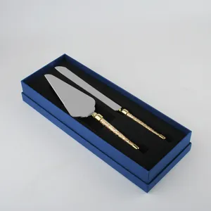 Juego de cuchillo y pala para tarta de acero con mangos de cristal dorado en caja.