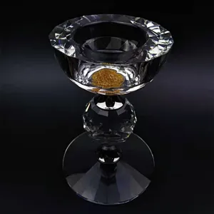 Elegante Nahaufnahme eines facettierten Kristallkerzenhalters mit goldenen Glitzerakzenten.