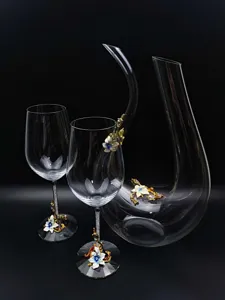 Detail view of crystal glass decanter and wine glass set with elegant enamel flower decor.