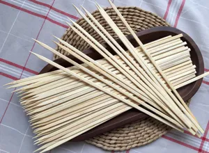 Gros plan détaillé de brochettes de barbecue en bambou disposées sur un plateau en bois, texture.