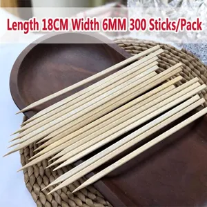 Close-up detail of 300 flat bamboo BBQ skewers with 18cm length on a wooden plate