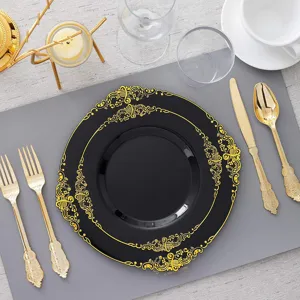 Détail des assiettes jetables noires avec bords dorés en relief et couverts assortis.