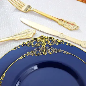 Gros plan d'une élégante assiette jetable bleu marine avec bord doré et couverts gaufrés