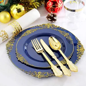 Détail du motif doré en relief sur assiette jetable bleue avec des couverts dorés.