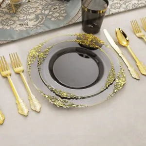 Détail d'assiettes jetables noires et dorées avec bordure fleurie en relief