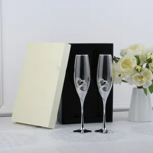 Pair of elegant crystal champagne flutes with rhinestone hearts in luxury gift box