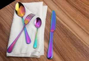 Close-up of a rainbow iridescent stainless steel cutlery set on a textured white napkin