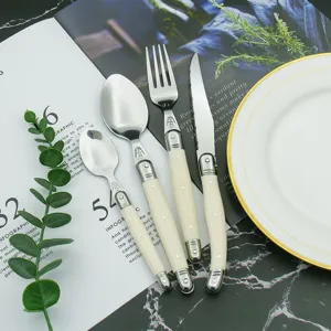Detailed view of Laguiole style cutlery set with bee emblem and ivory white handles