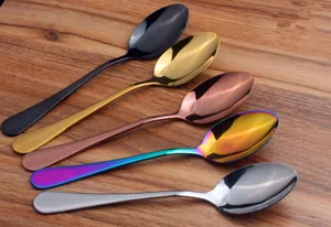 Set of multi-colored stainless steel spoons displayed on a rustic wood background.