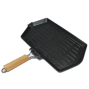 Detail view of the foldable wooden handle on a ridged cast iron steak grill pan