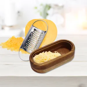 Rallador de queso de acero inoxidable con cuenco de madera de acacia en mesa blanca