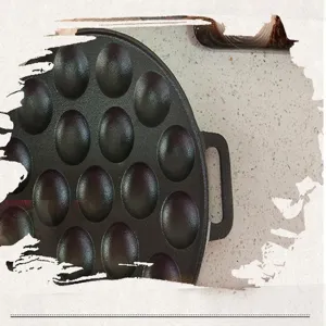 Close-up detail view of a 19-hole cast iron takoyaki pan with matte finish and dual handles