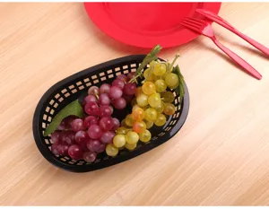 Vue de dessus d'un panier en plastique ovale noir de 9 pouces avec des raisins factices