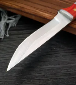 Dettaglio ravvicinato di una lama di coltello in acciaio al carbonio con manico rosso