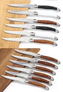 Detailed close-up of serrated stainless steel steak knives with laser patterned blades and handles.