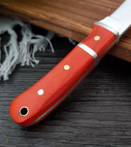 Primo piano del manico in legno rosso di una mannaia da carne forgiata con rivetti.