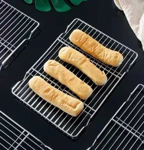 Primo piano di pane appena sfornato su una griglia di raffreddamento in acciaio