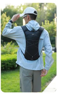 Back view of a man wearing a black hydration pack in a sunny outdoor park environment