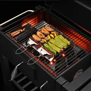Nahaufnahme von Edelstahl-Grillspießen mit drei Zinken, gegrilltem Huhn und Paprika