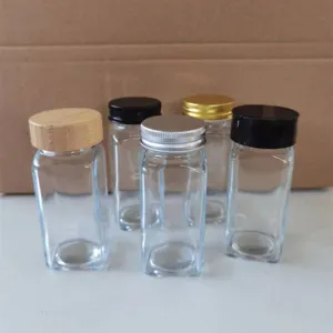 Ensemble de pots à épices en verre carrés avec divers couvercles pour la cuisine.