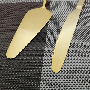 Detail van de goudkleurige roestvrijstalen taartmes en taartschep set met kartels