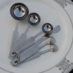 Close-up of premium 6-piece stainless steel measuring spoons set with engraved scale markings.