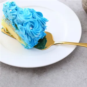 Close-up van gouden roestvrijstalen taartschep met een stukje blauwe roos cake