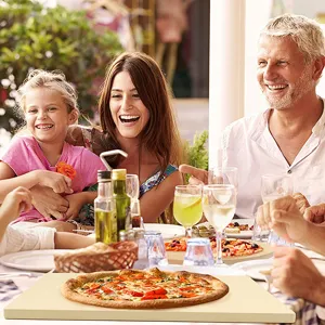 Pietra refrattaria quadrata con pizza fresca durante una cena di famiglia all'aperto