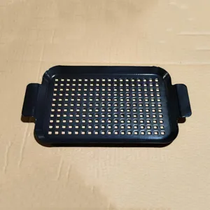 Detailaufnahme einer rechteckigen schwarzen Emaille-BBQ-Grillschale mit vielen Löchern