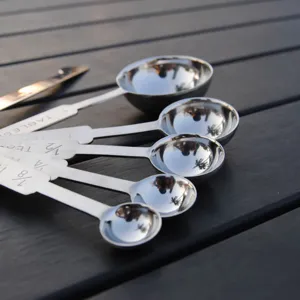 Professional 304 stainless steel measuring spoons set for baking on dark background.
