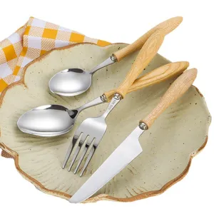 Premium 304 stainless steel cutlery set with natural ash wood handles on ceramic plate