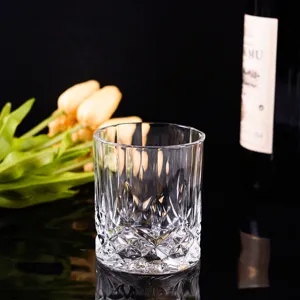 Elegant crystal whiskey glass with a thick base and diamond carved patterns on black background